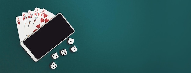 Jugando a las cartas, dados de póquer y teléfono en el panorama de tela azul verde