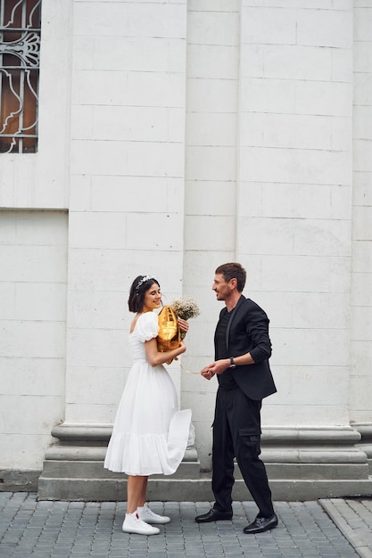 Jugando con globo de color dorado Hermosa novia con su prometida está celebrando la boda al aire libre