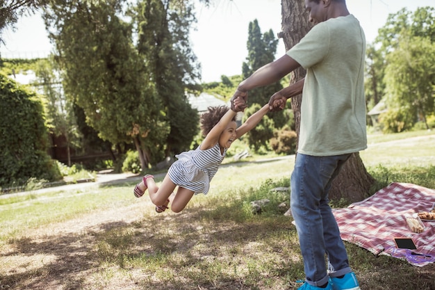 Jugando en el parque. papá y su hija pasando un buen rato juntos en el parque y sintiéndose juguetones