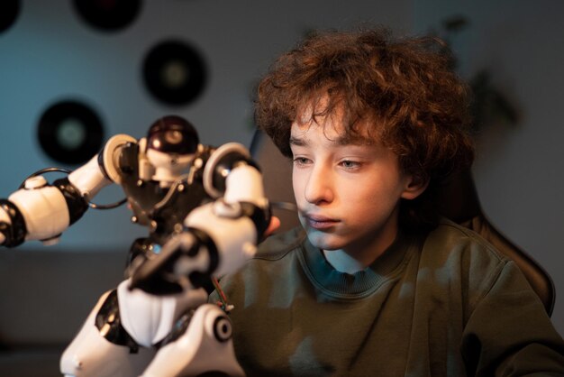 Jugando con un robot en una habitación oscura con un niño que brilla azul mira el juguete con cuidado
