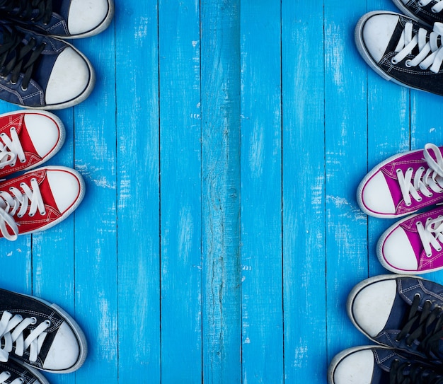 Foto jugend färbte turnschuhe auf einem blauen hintergrund der hölzernen planken