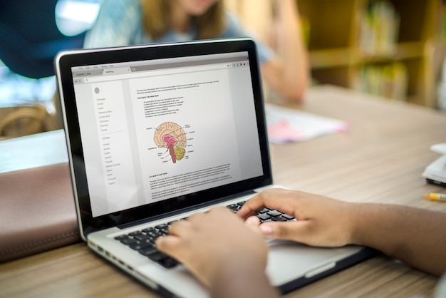 Jugendhände unter Verwendung eines Laptops, der Biologie studiert