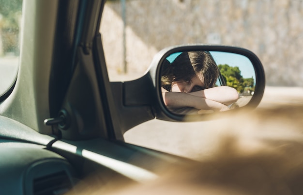 Jugendlich Mädchen, das im Auto an einem Sommernachmittag sitzt