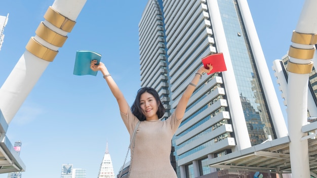 Jugendlich Mädchen des Studenten mit dem Bildungsbuch, das mit dem Gefühl glücklich steht