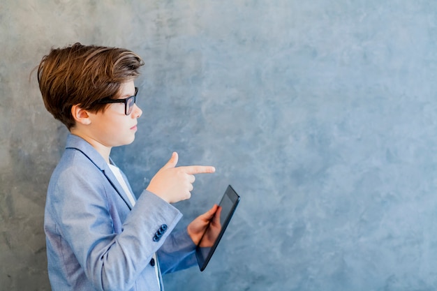 Jugendlich Schülerjunge in den Brillen hält Tablet-PC