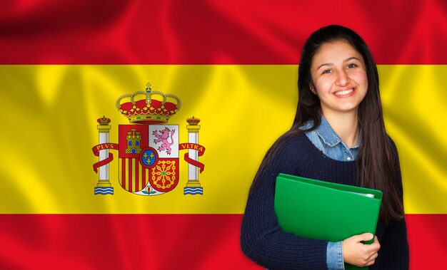 Jugendlich Student, der über spanischer Flagge lächelt