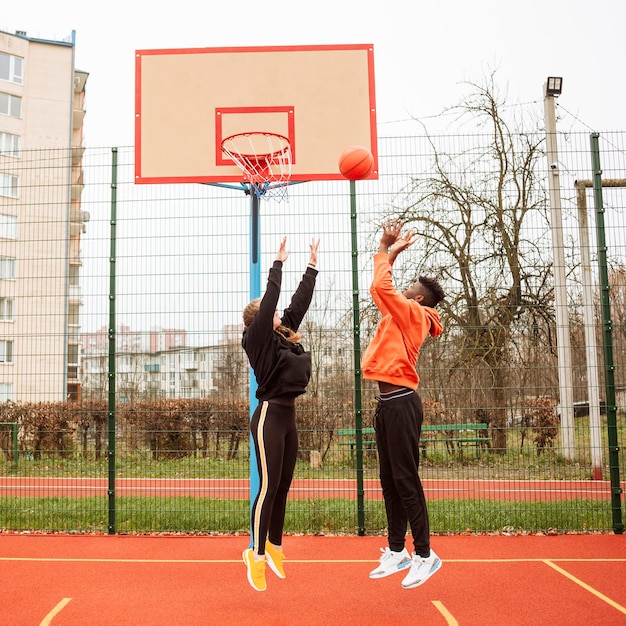 Jugendliche auf dem Basketballplatz zusammen