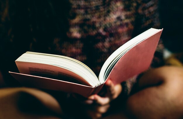 Jugendliche, die ein Buch in einem Schlafzimmer liest