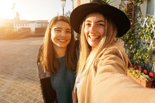 Jugendliche, die selfie im Sonnenuntergang nehmen Mädchen, die an der Kamera lächeln und Spaß haben