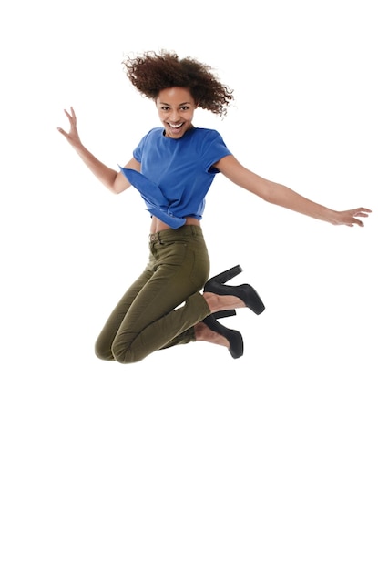 Jugendliche Energie und Überschwang Junge afrikanische Frau springt mit einem Lächeln, während isoliert auf weiß