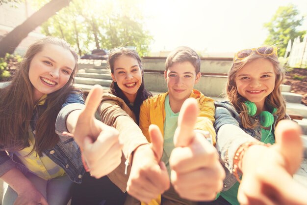 Foto jugendliche freunde oder schüler zeigen den daumen nach oben