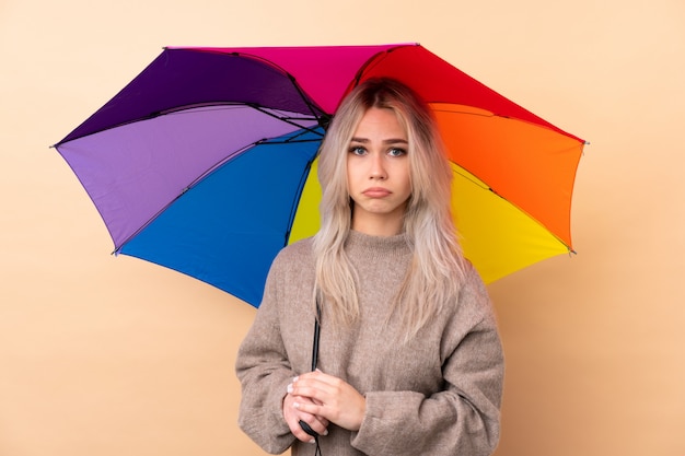 Jugendlicher, der einen Regenschirm traurig hält