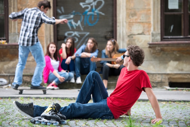 Jugendlicher, der seinen Freund auf Skateboard betrachtet