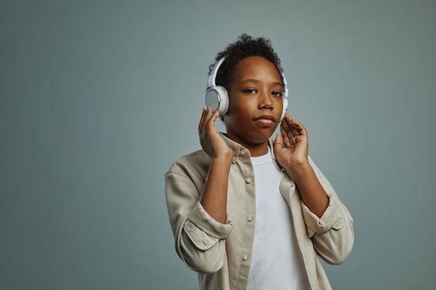 Jugendlicher Schüler berührt weiße Kopfhörer, während er seine Lieblingsmusik hört und ca