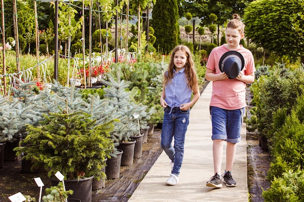 Jugendliches Mädchen und Teenager, die im Park oder Garten spazieren gehen Zuerst ohne Erwachsene abhängen Zeit im Freien verbringen