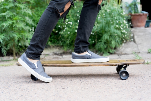 Jugendlichjunge, der auf Skateboard am allgemeinen Park spielt