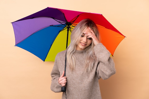 Jugendlichmädchen, das einen Regenschirm über getrenntem Wandlachen anhält