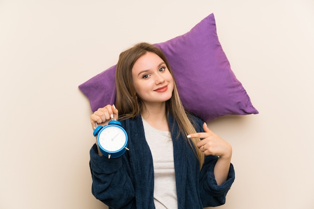 Foto jugendlichmädchen in den pyjamas, die weinleseuhr halten