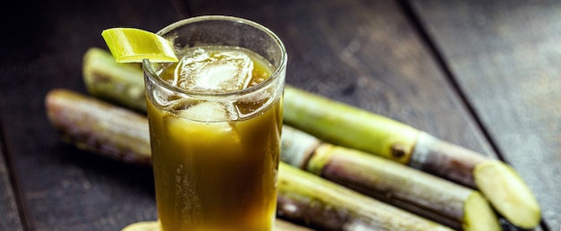 Jugo de caña de azúcar, jugo verde dulce, rico en acarosi, sobre mesa de madera rústica