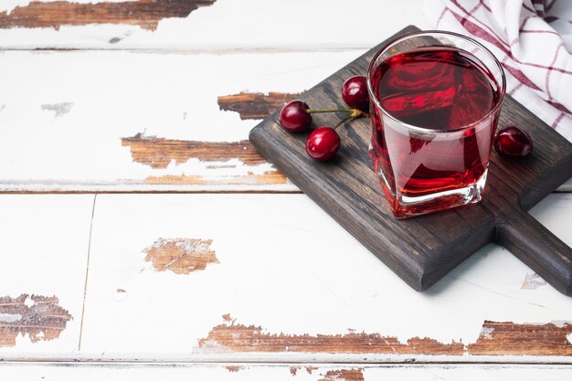 Jugo de cereza en vasos de vidrio con cerezas frescas.