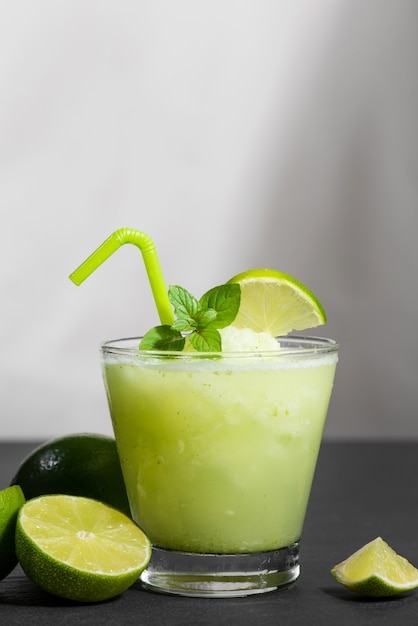 Jugo de cóctel con lima, menta y hielo. Accesorios para bebidas de bar en el fondo de la tabla negra.