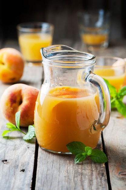 Jugo de durazno fresco con menta en la mesa de madera