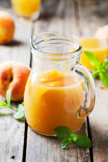 Jugo de durazno fresco con menta en la mesa de madera