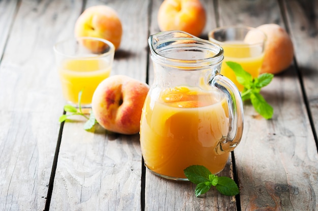 Jugo de durazno fresco con menta en la mesa de madera