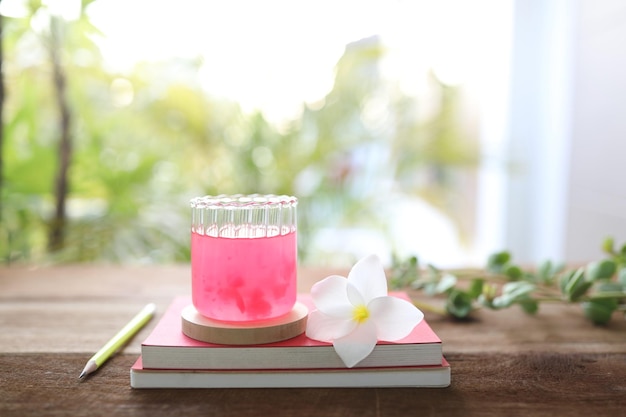 Jugo de fresa roja hielo y cuadernos y flor