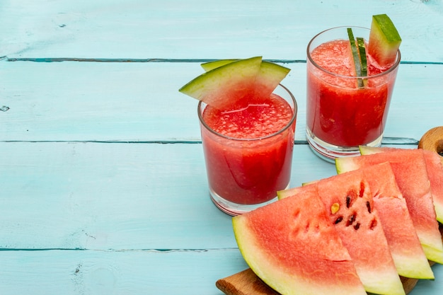 Jugo fresco de sandía, batido, cóctel. Postre dulce de verano, rebanadas en tabla de cortar de madera