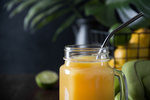 Foto jugo de frutas frescas de verano con limón, lima en la mesa oscura.