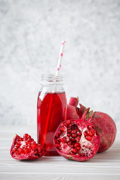 Jugo de granada en botella y fruta.