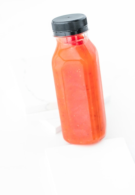 Jugo de licuado de frutas rojas de desintoxicación en una entrega de catering de dieta de botella aislado sobre fondo blanco
