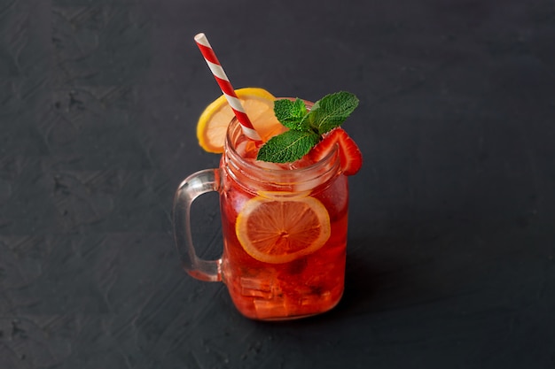 Jugo de limonada fría de fresa con cubitos de hielo, limón y menta.