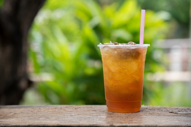 Jugo de longan en vaso de plástico con fondo natural de hoja verde