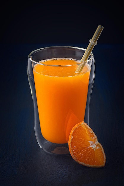 Jugo de mandarina fresco en una mesa azul marino