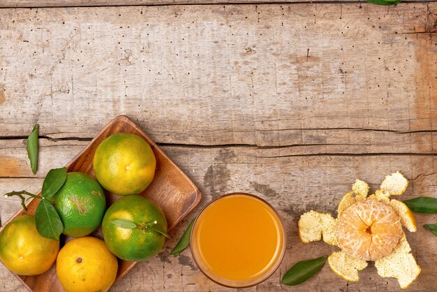 Jugo de mandarina pelado fresco en vidrio sobre fondo de madera.