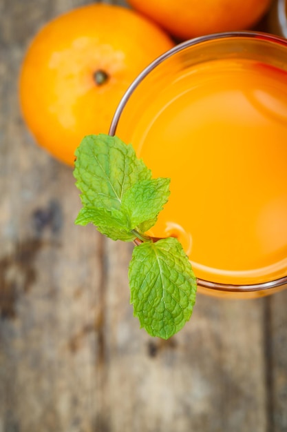 Foto jugo de mandarina en una tabla de madera