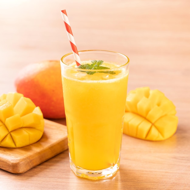 Jugo de mango fresco con hermosa carne de pulpa picada sobre fondo de mesa de madera brillante Concepto de diseño de bebida de frutas tropicales Cerrar espacio de copia