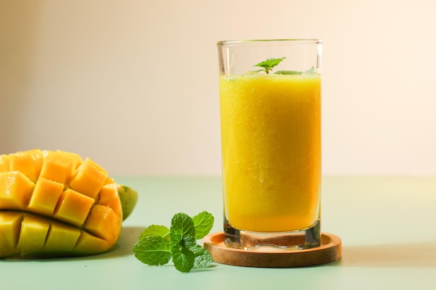 Jugo de mango fresco servido con un color de fondo verde natural junto con rodajas de mango Arumanis