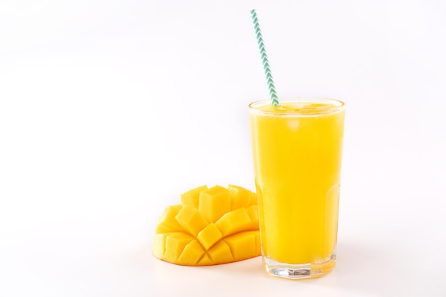 Jugo de mango tropical fresco con hermosa pulpa cortada en cubitos y paja de papel rayado aislado en la mesa de fondo blanco cerca del trazado de recorte recortado