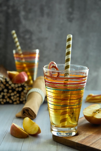 Jugo de manzana fresco en un vaso, paja, manzanas rojas