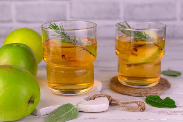 Jugo de manzana fresco en vasos sobre un fondo blanco de madera