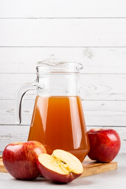 Jugo de manzana y manzanas rojas sobre la mesa.