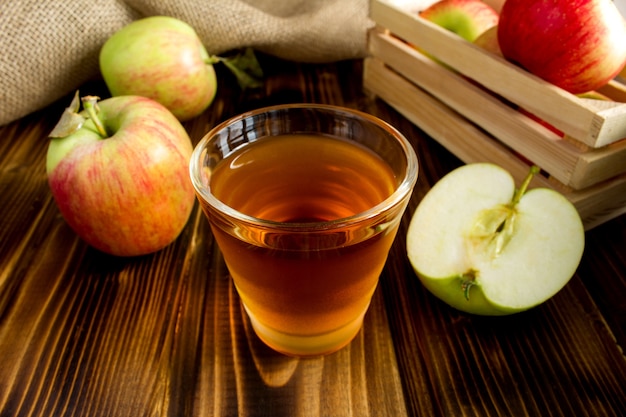 Jugo de manzana en el vaso de madera marrón