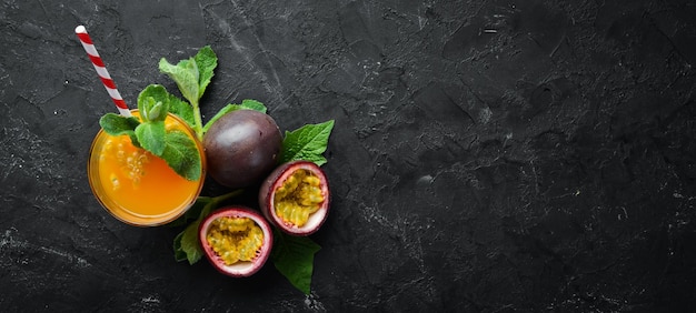 Jugo de maracuyá y fruta sobre un fondo negro Frutas tropicales Vista superior Espacio libre para texto