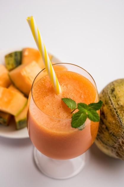 Jugo de melón almizclero con rodajas, también conocido como extracto de fruta kharbuj o kharbuja, servido en un vaso con menta. enfoque selectivo