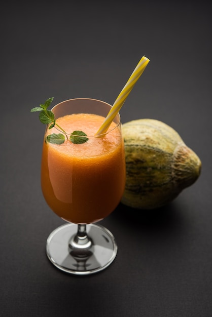 Jugo de melón almizclero con rodajas, también conocido como extracto de fruta kharbuj o kharbuja, servido en un vaso con menta. enfoque selectivo