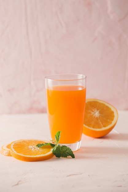 Jugo de naranja aislado con rodajas de naranjas sobre fondo blanco.