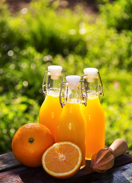 jugo de naranja en botellas y mudler de madera